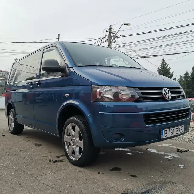 O dubă Volkswagen albastră în fața service-ului.